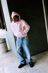 Model wearing the baby pink Drama Call STA zip-up hoodie in a lifestyle view.
