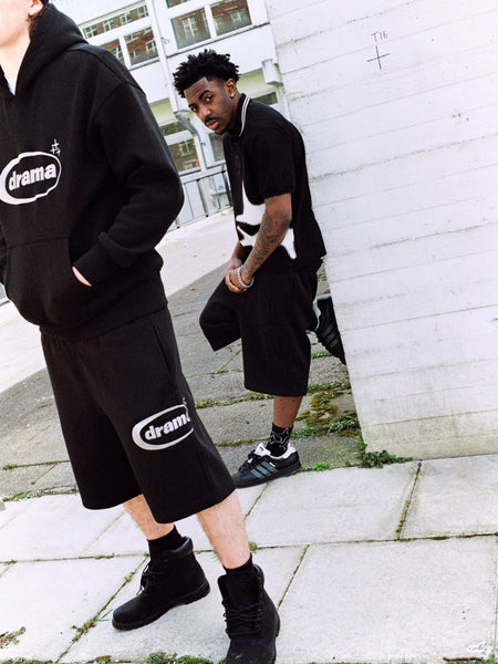Model wearing the black Drama Call oval logo mens hoodie