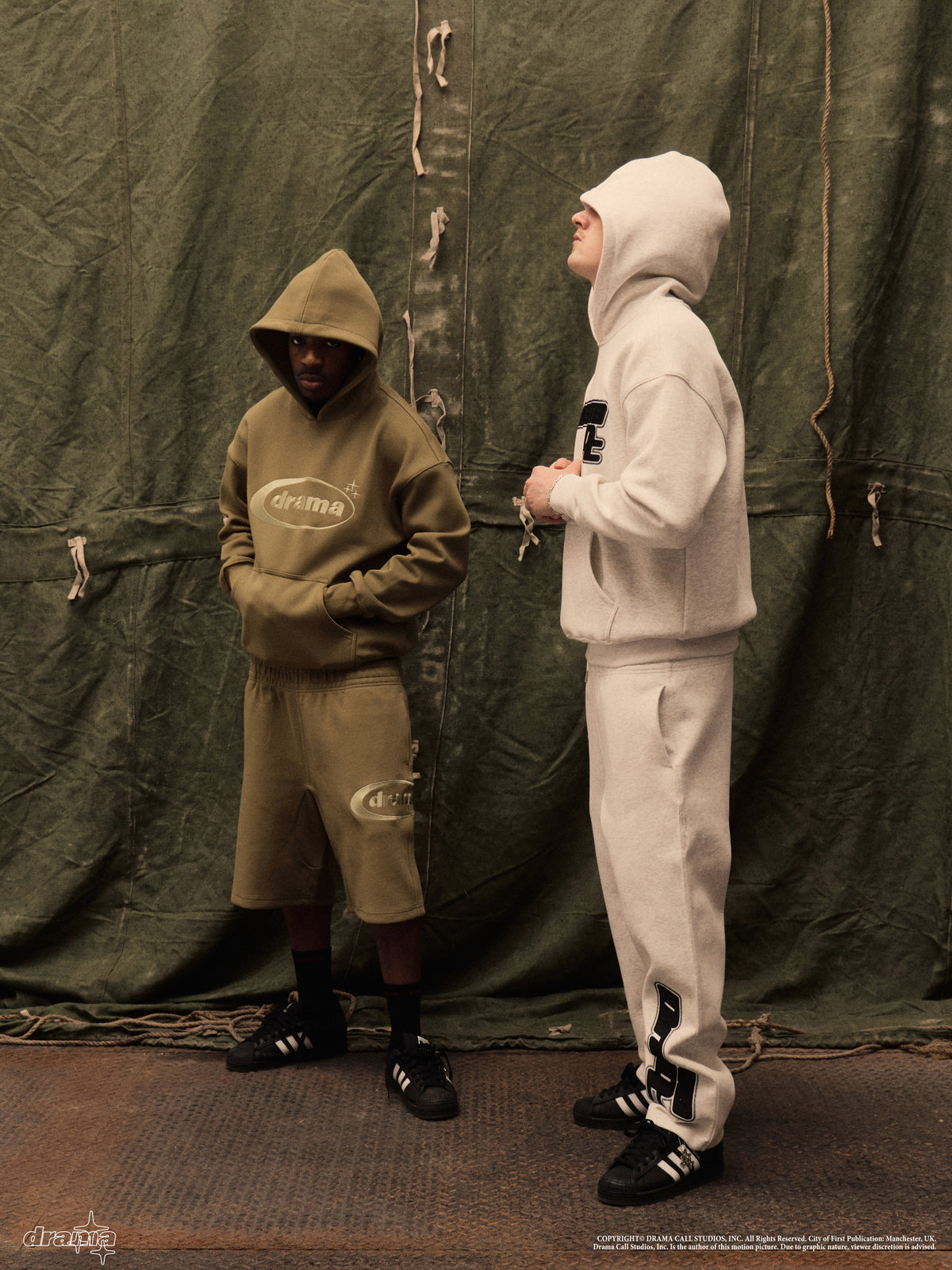 Two models wearing green and grey Drama Call hoodies