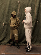 Two models wearing green and grey Drama Call hoodies
