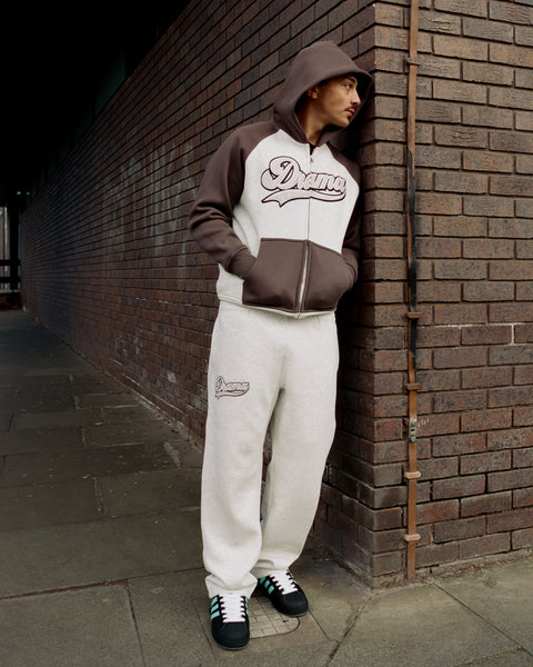 Model wearing the Drama Call grey and black script stud zip-up hoodie