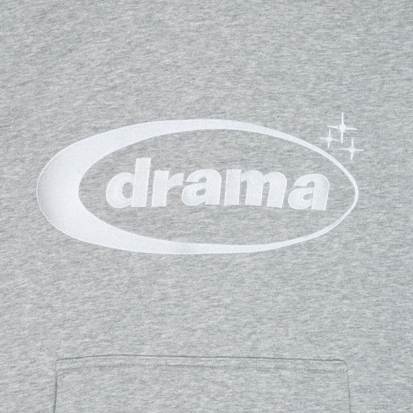 Close-up of the embroidered white oval drama logo 