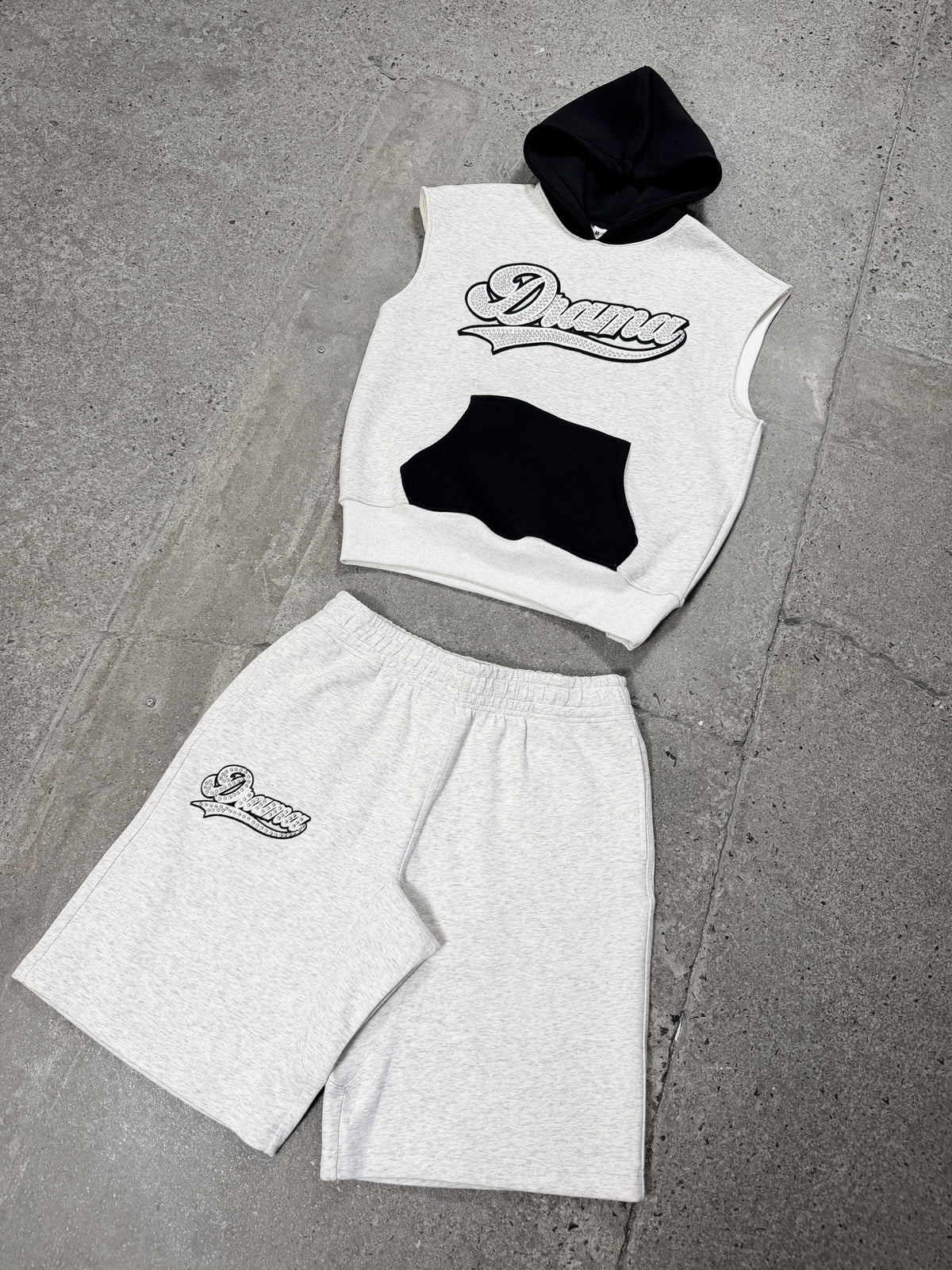 Men's grey Drama Call stud script vest hoodie set in a flat lay view.