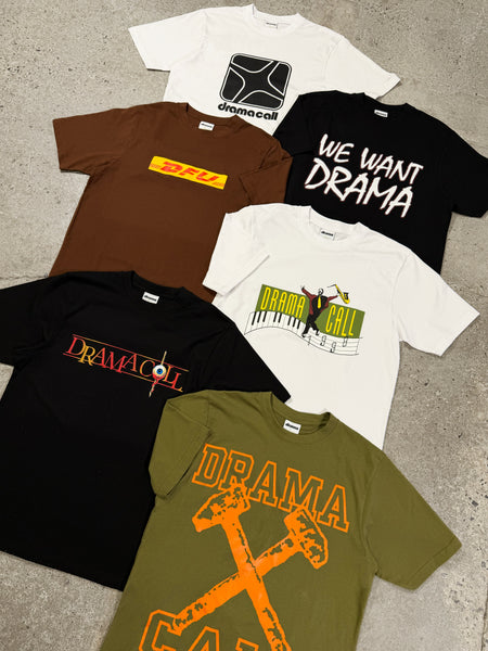 A flat lay view of multiple Drama Call streetwear graphic tees in various colors and designs arranged