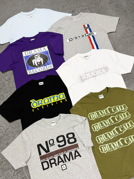 Flat lay view of multiple Drama Call graphic tees in various colors and streetwear designs