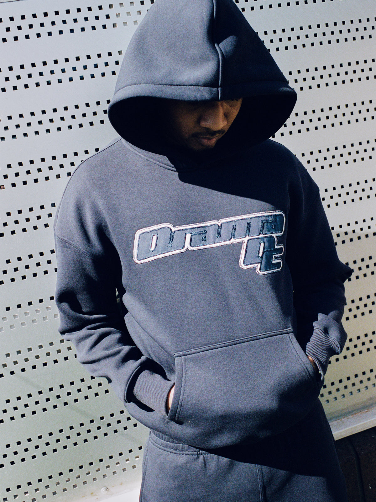 Model wearing a navy Drama Call AV Sport hoodie