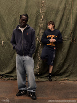 Two male models showcasing the navy Drama Call STA zip-up hoodie