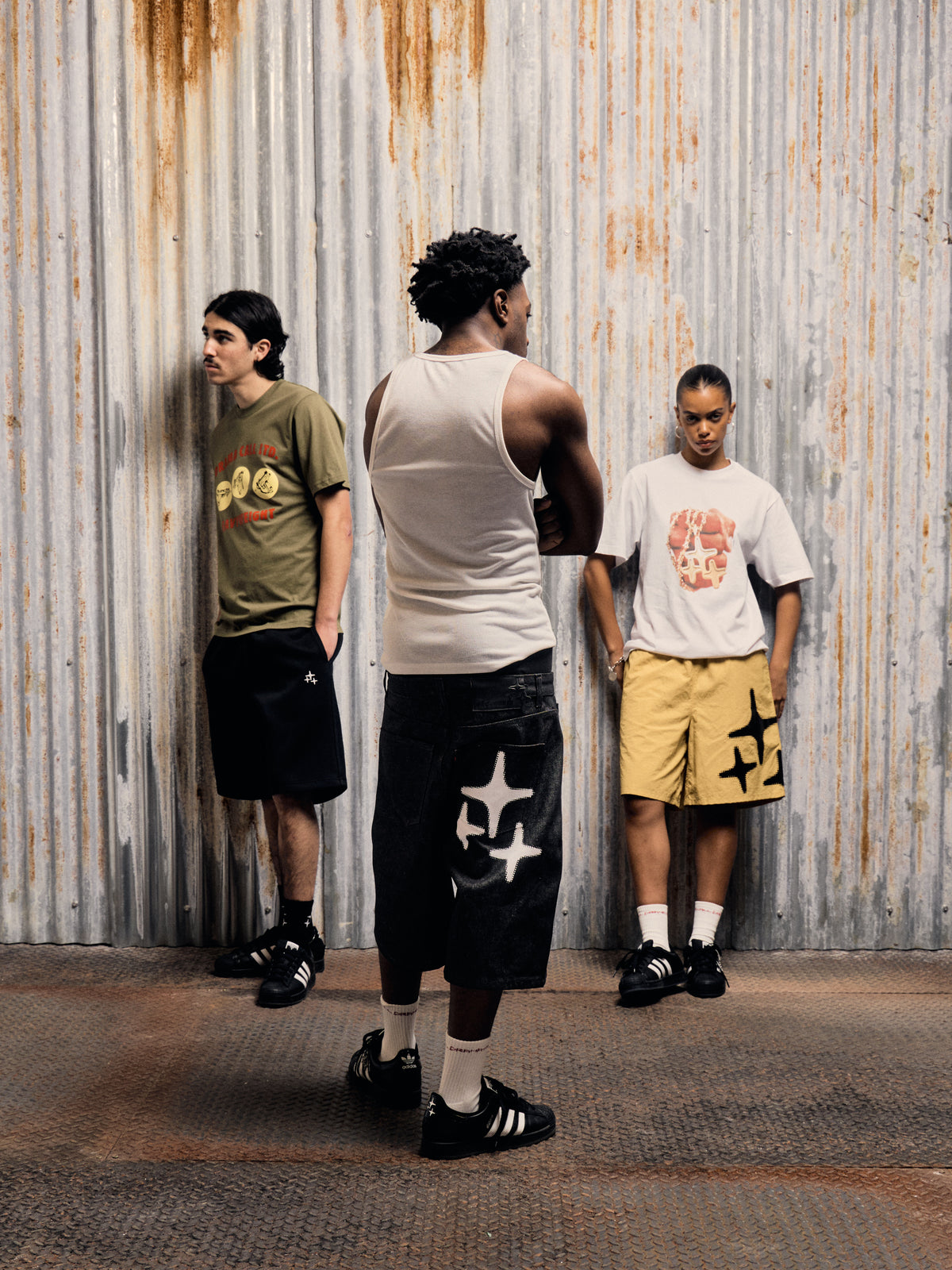 Lifestyle shot of three models against a corrugated metal wall