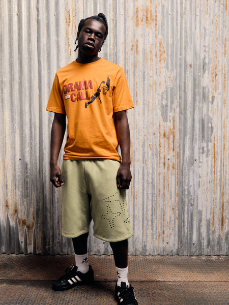 A male model wearing the Drama Call orange Jump graphic tee
